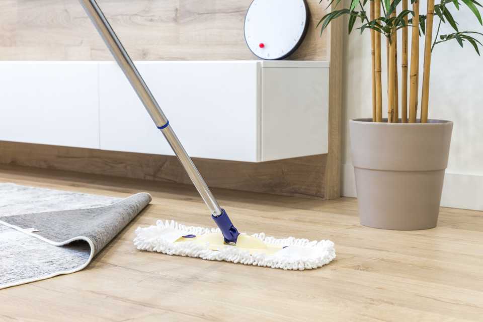 dry mopping light oak wood look luxury vinyl in bathroom 